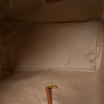 Tote bag interior with beige lining, stitched pocket seam and leather pull tab