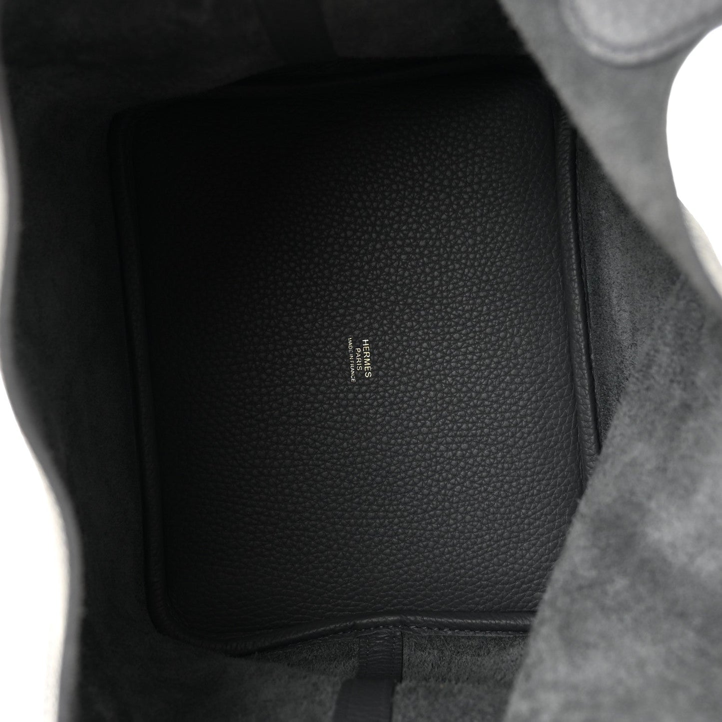 Interior of dark gray leather handbag showing subtle embossed brand text
