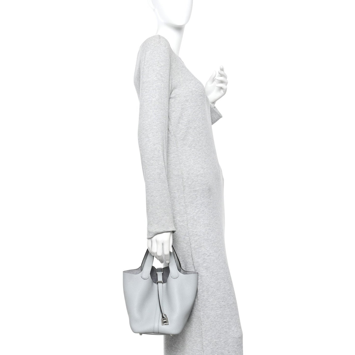 Light blue pebbled leather bucket tote bag worn by person with top handles
