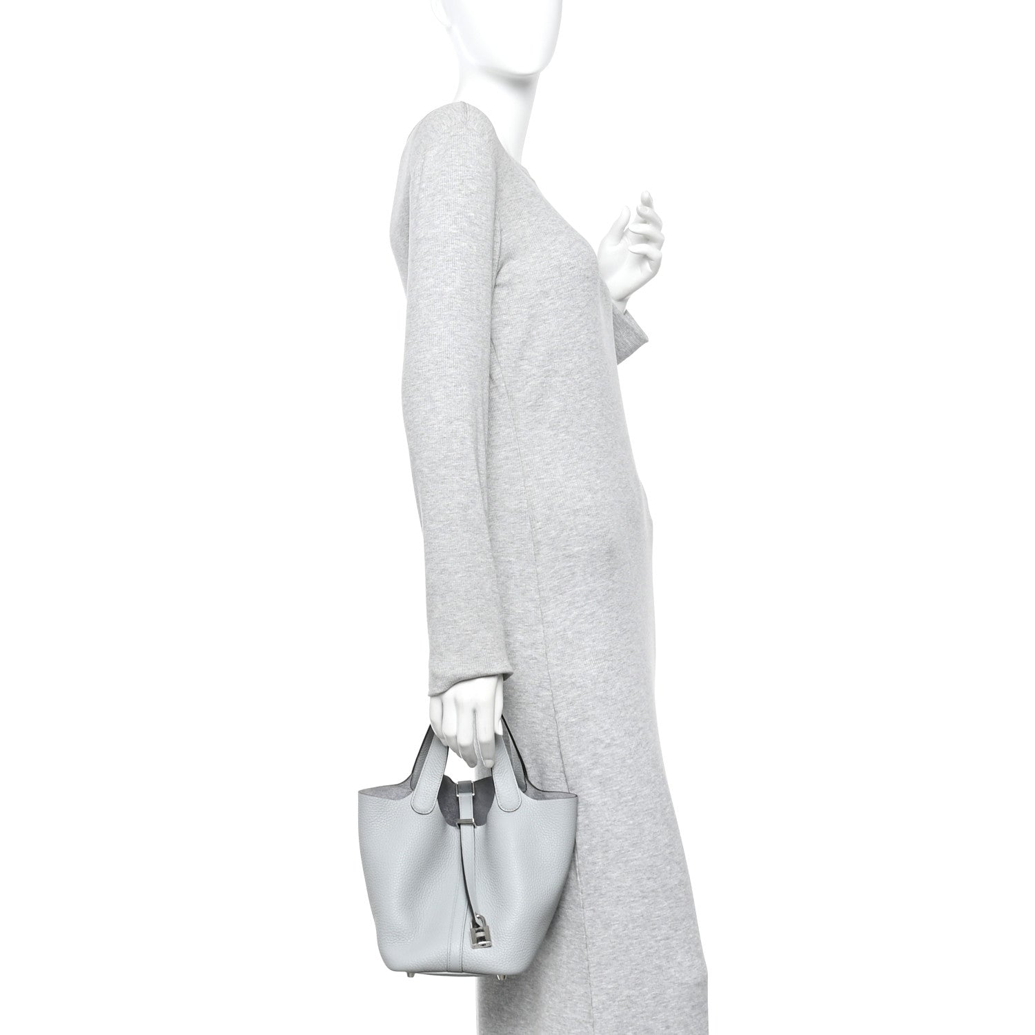 Light blue pebbled leather bucket tote bag worn by person with top handles