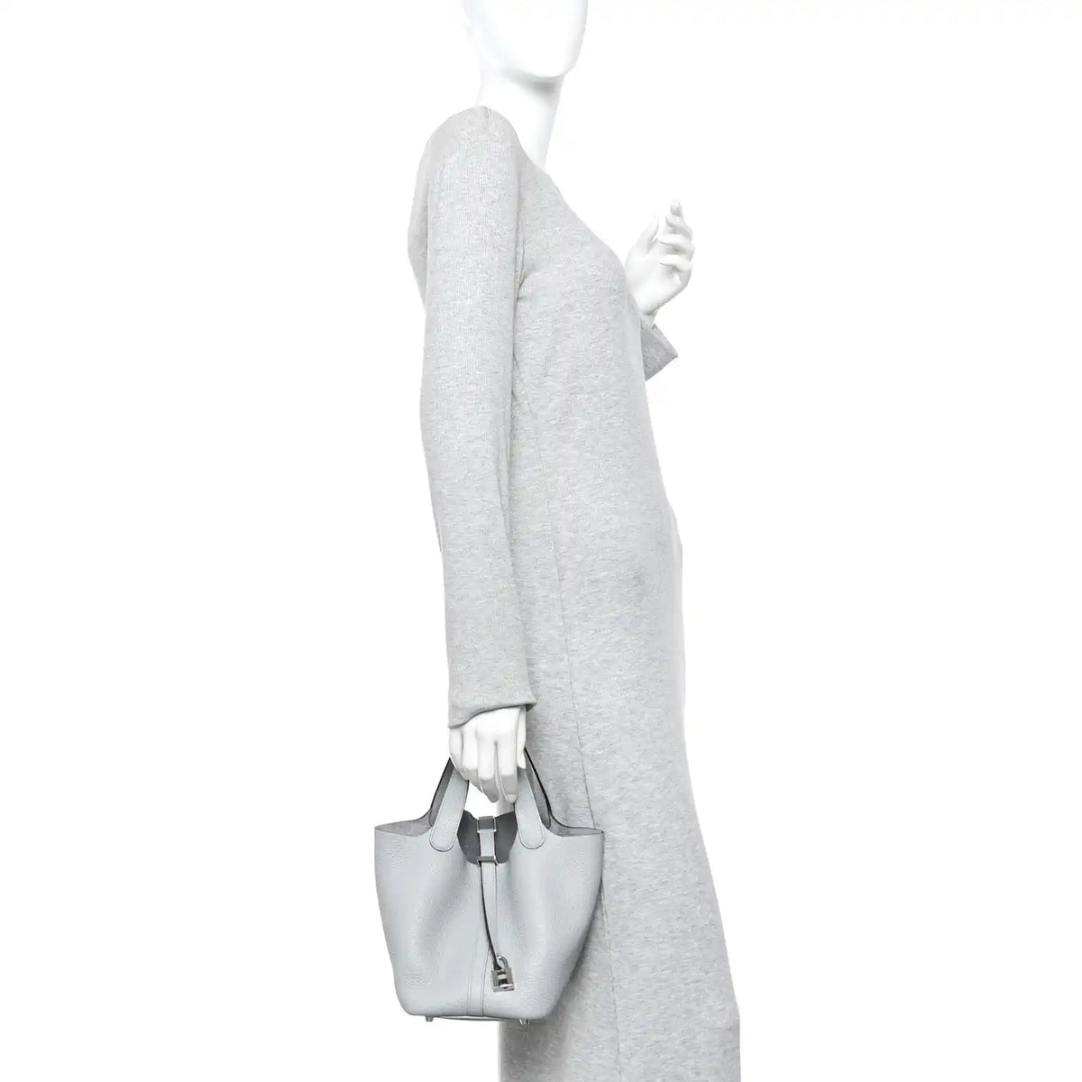 Light blue pebbled leather bucket tote bag worn by person with top handles