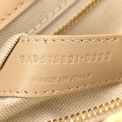 Beige leather strap end with embossed code and stitched trim