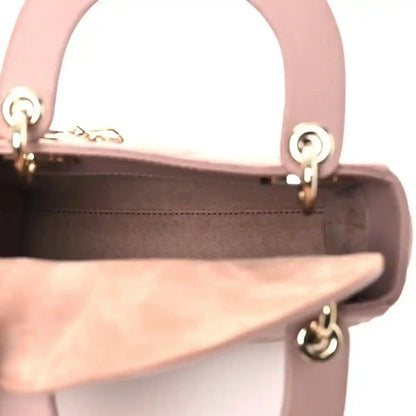 Mini Lady Dior handbag interior opening view with pink leather lining and gold-tone ring hardware.
