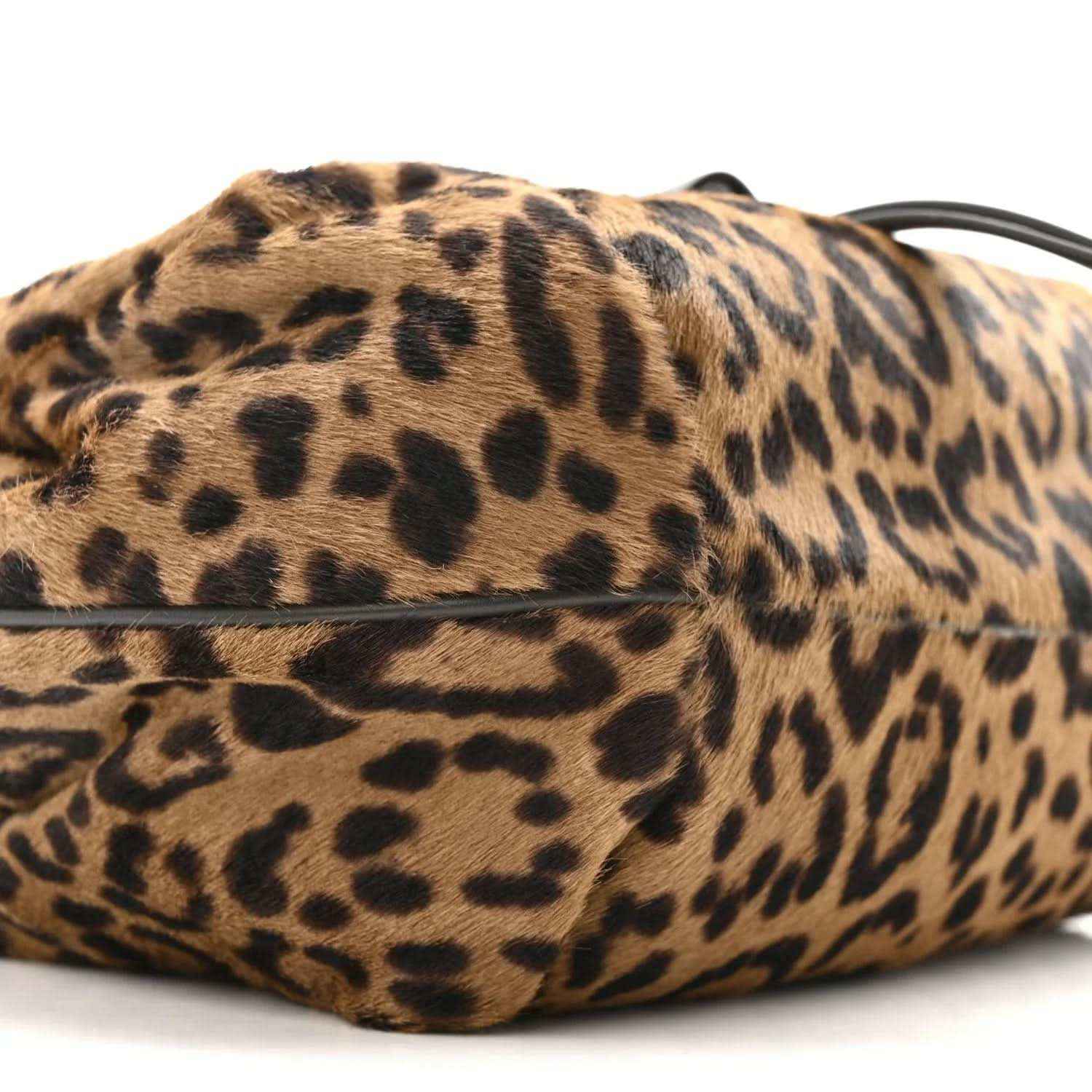 Leopard-print mini spy bag side view with black strap and textured body.
