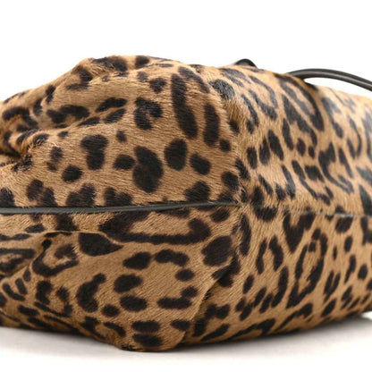 Leopard-print mini spy bag side view with black strap and textured body.