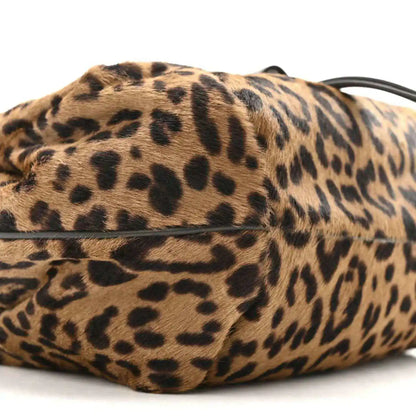 Leopard-print mini spy bag side view with black strap and textured body.