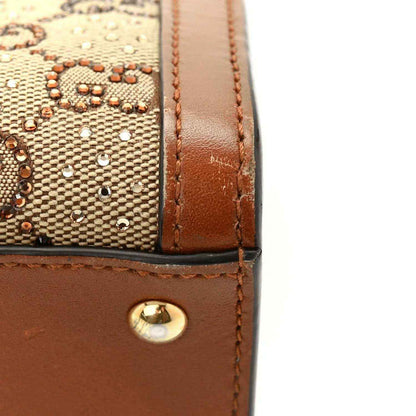 Mini Diana tote bag corner with brown leather panel, gold snap detail on canvas