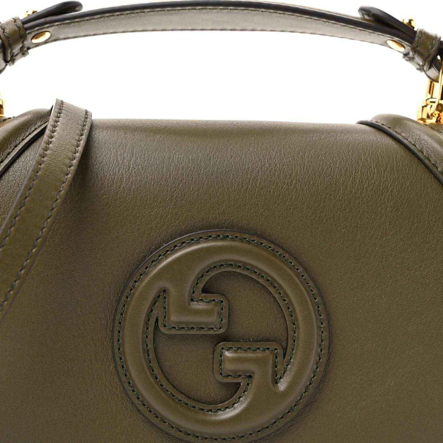 Green leather handbag with circular logo emblem at the front