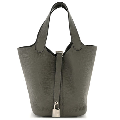 Tote-style leather bucket bag with two rolled handles and center zip pocket, dark green