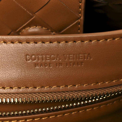 Amber suede edge with logo, tan topstitching, and gold zipper pull