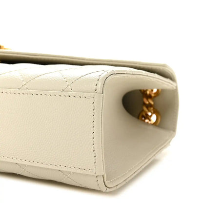 Cream quilted satchel side panel with stitching and gold chain connector