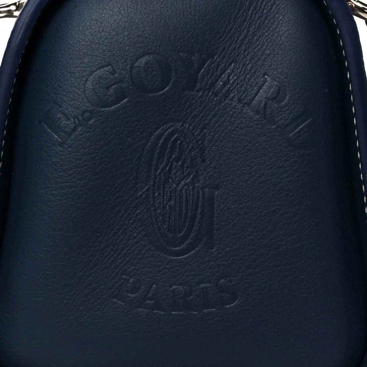 Close-up of navy leather Goyardine Bonbonniere bag with embossed Goyard logo