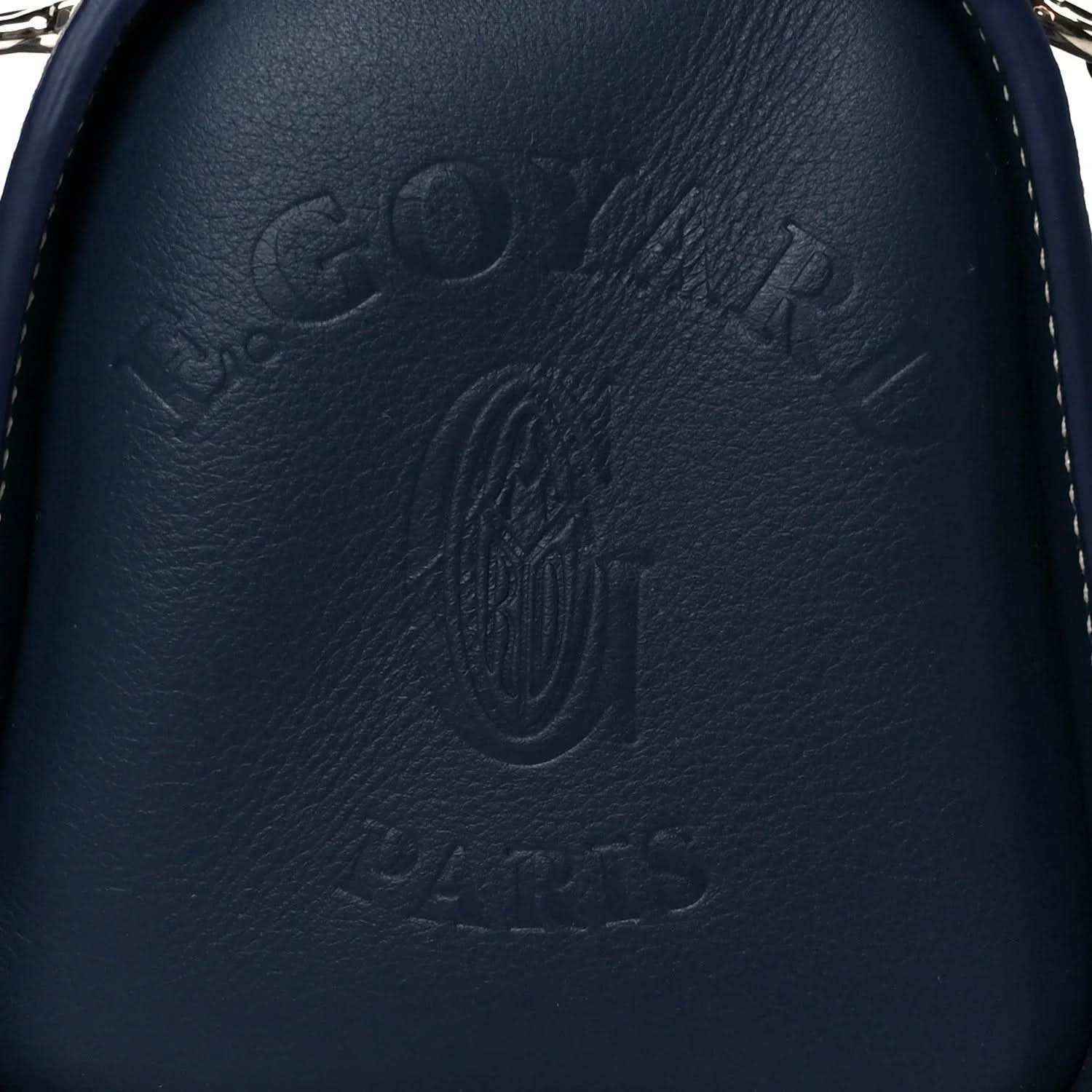 Close-up of navy leather Goyardine Bonbonniere bag with embossed Goyard logo
