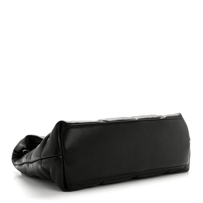 Black quilted puffer satchel with smooth trim edges, side angle view