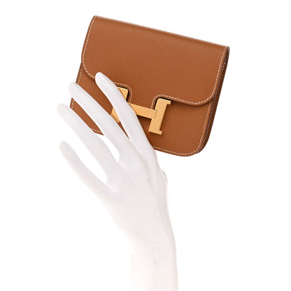 Hermes Constance slim wallet with fold-over flap and gold-tone H clasp, textured brown leather