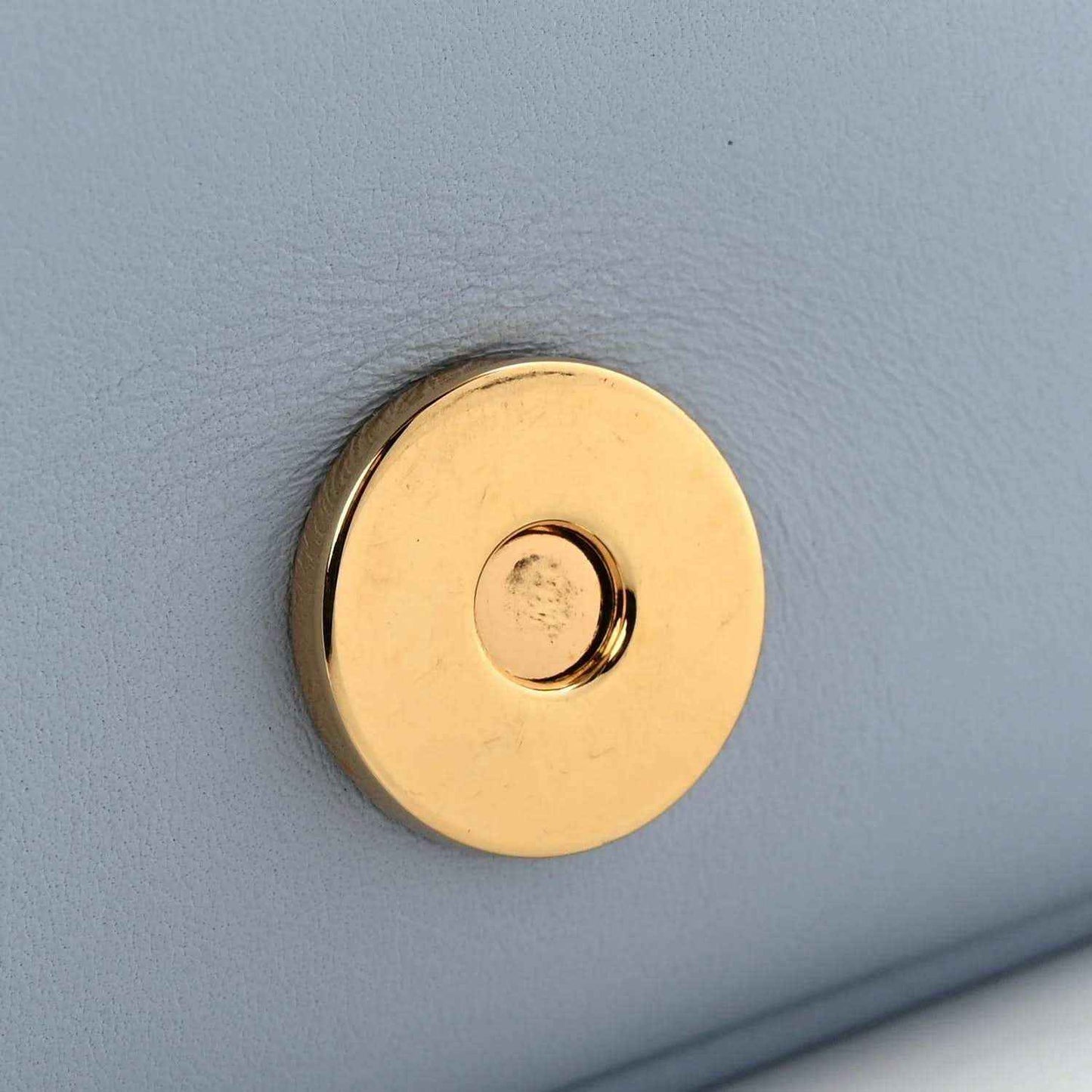Medium top handle bag with round gold logo clasp on cloudy blue leather