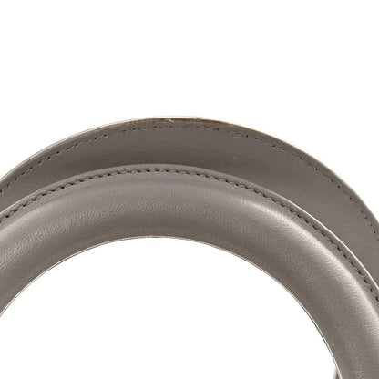 Grey leather handbag strap end with curved edge and neat stitching