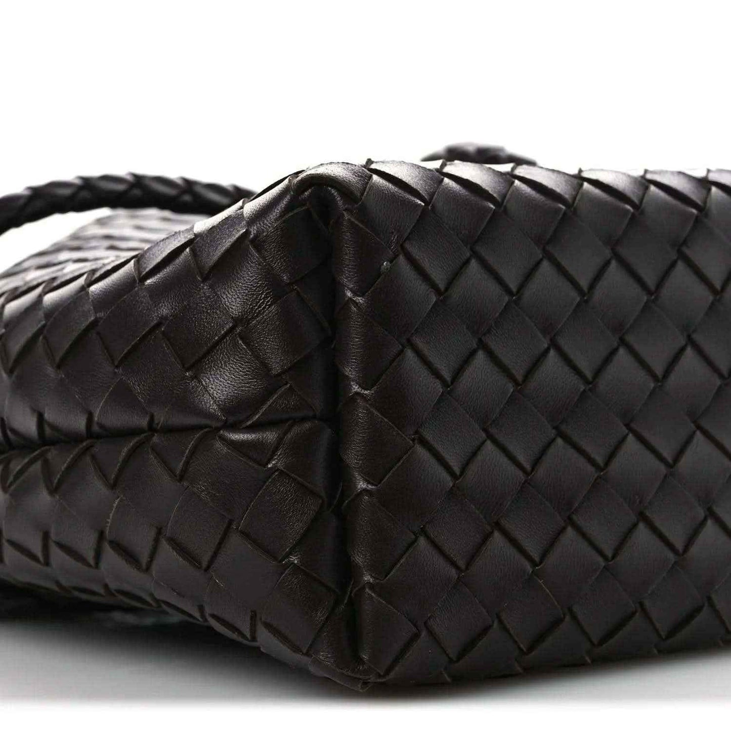 Small intrecciato nappa leather bucket bag close-up, dark color, woven texture and fold