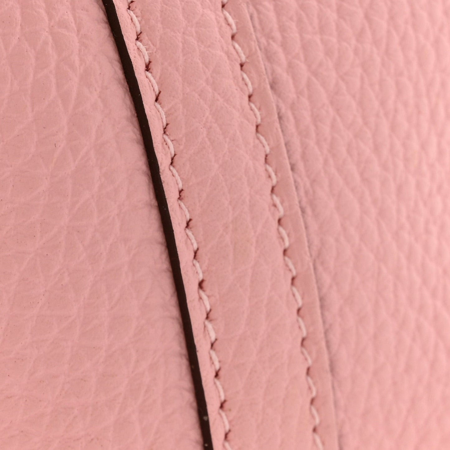 Rose pink leather seam with close-up stitched border and textured grain