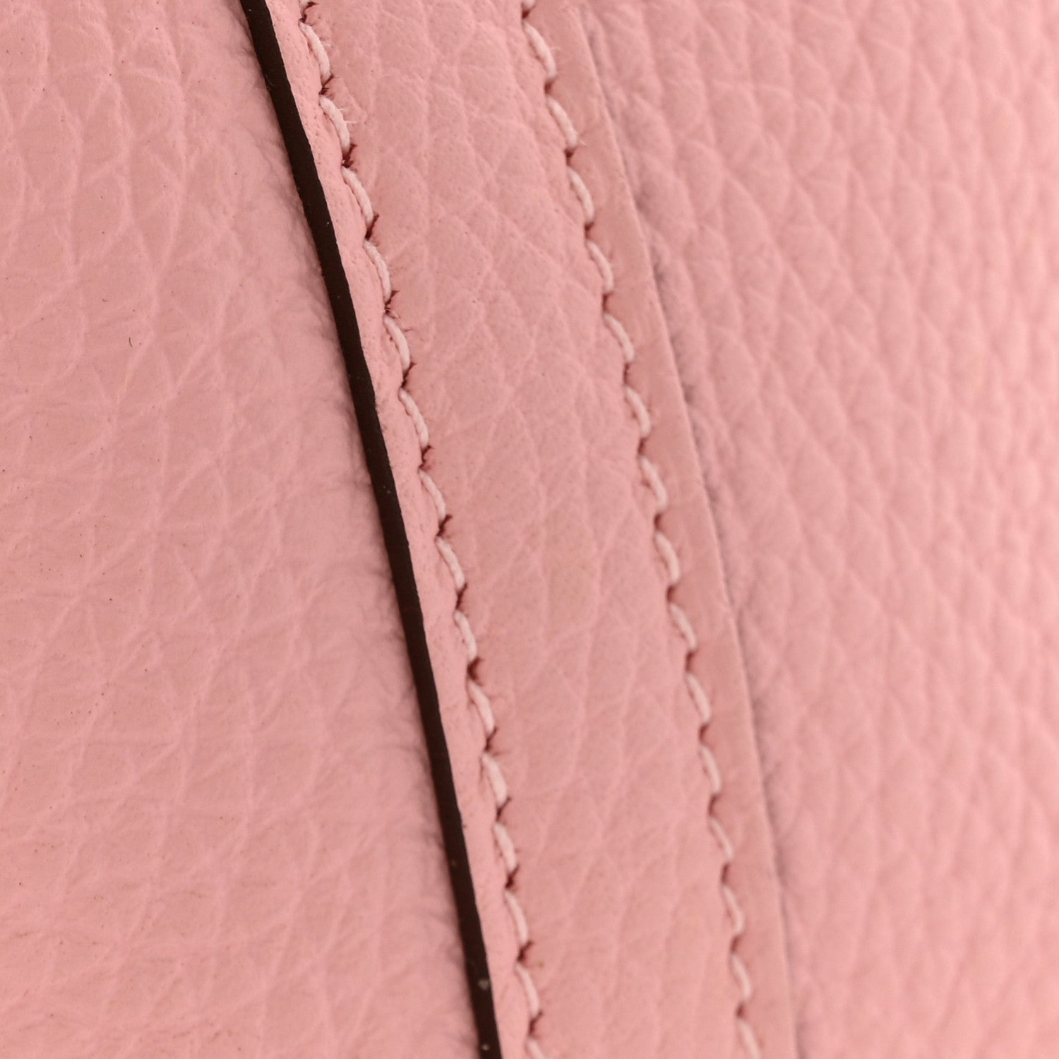 Rose pink leather seam with close-up stitched border and textured grain