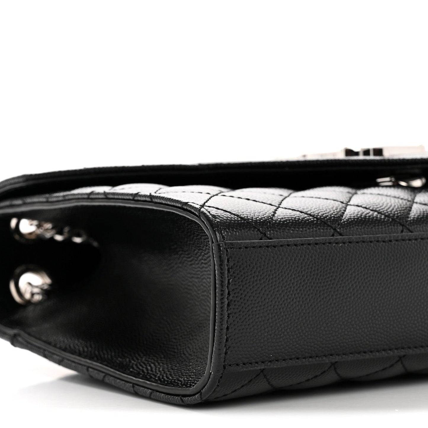 Black quilted satchel side view with chain strap hardware and curved base