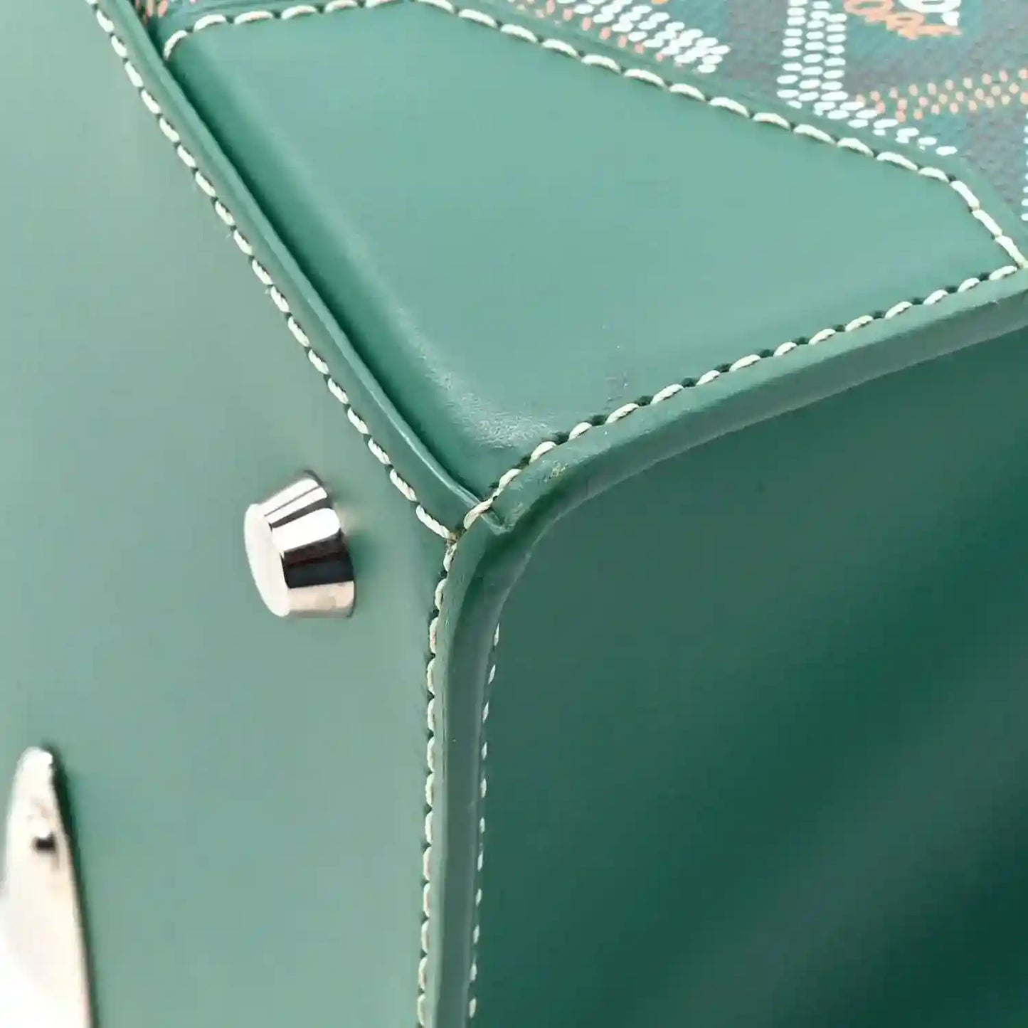 Green Goyardine Saigon PM bag side corner with white stitching and metal snap detail