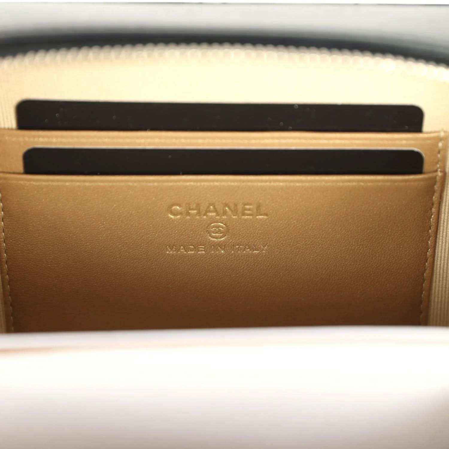 Chanel logo stamp on beige lining inside clutch, with zip opening edge