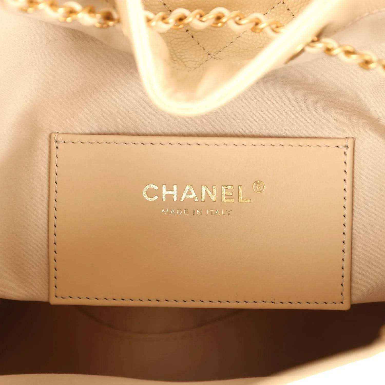 Chanel brand patch on light beige leather interior lining with stitched border