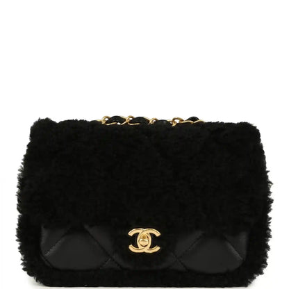 Black mini flap bag with shearling and quilted flap, gold CC logo and chain handle