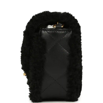 Black mini flap bag with shearling and leather back panel, small gold hardware