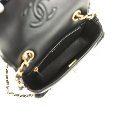Black mini flap bag with gold-tone chain, quilted lambskin flap and turn-lock clasp