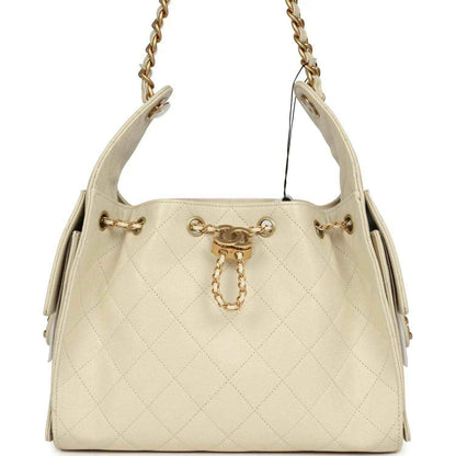 Light beige caviar hobo bag with gold-tone chain handles and front charm hardware
