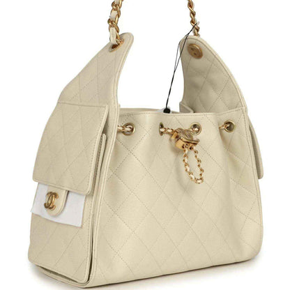 Light beige caviar hobo bag with gold-tone chain handles, front latch, and side charm