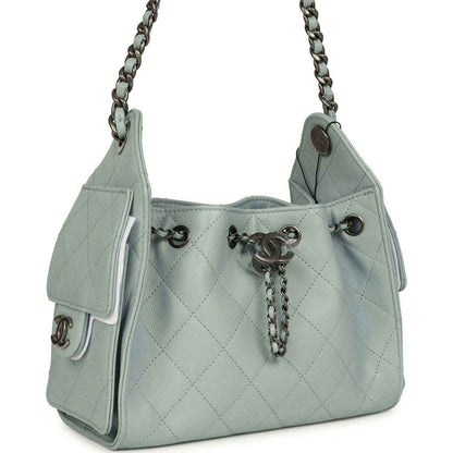 Light blue quilted mini hobo bag with chain strap, front snap pocket, and turn-lock