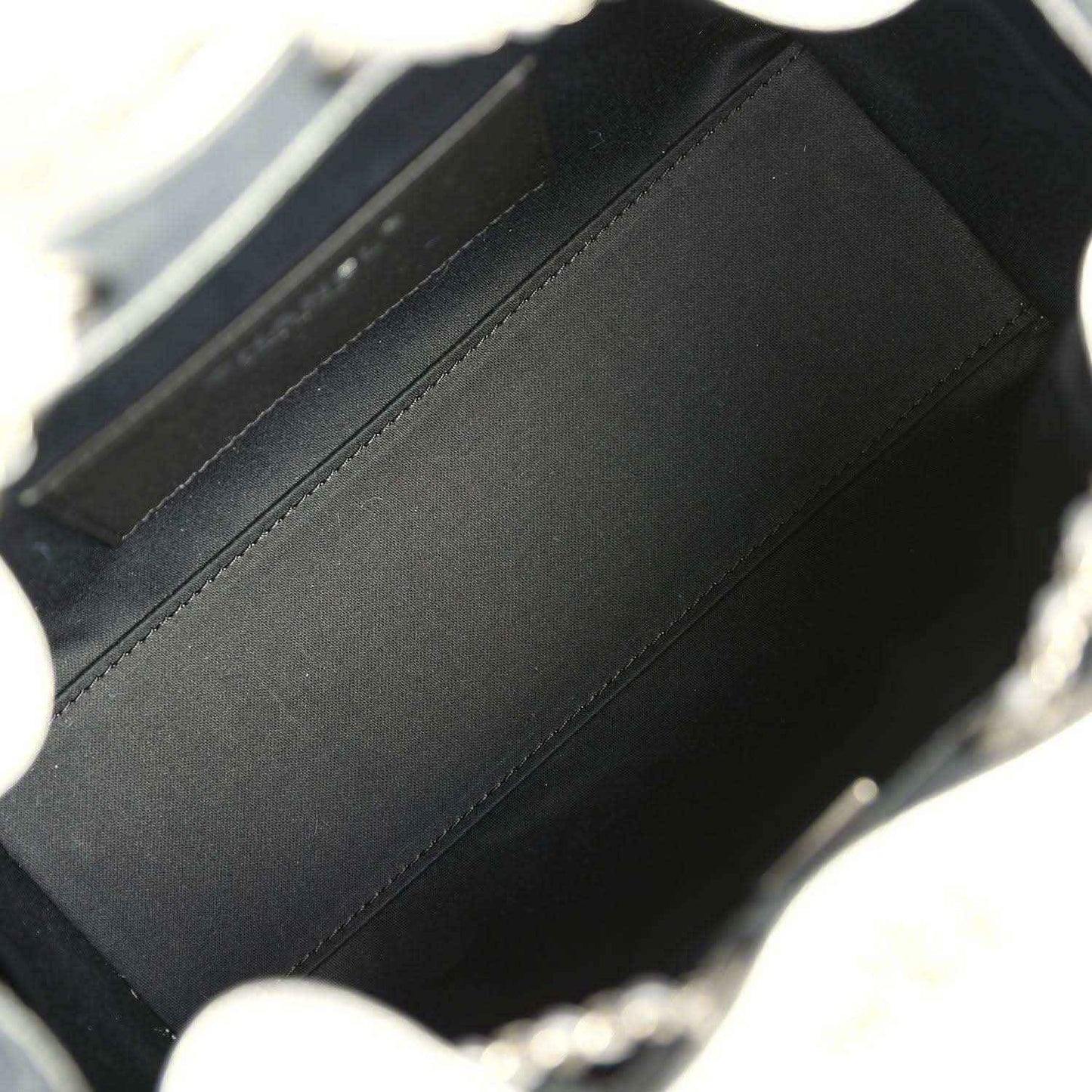 Black fabric lining inside mini hobo bag, visible seam and inner wall