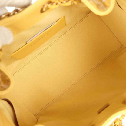 Yellow fabric interior pocket of quilted hobo bag, visible stitching and tab