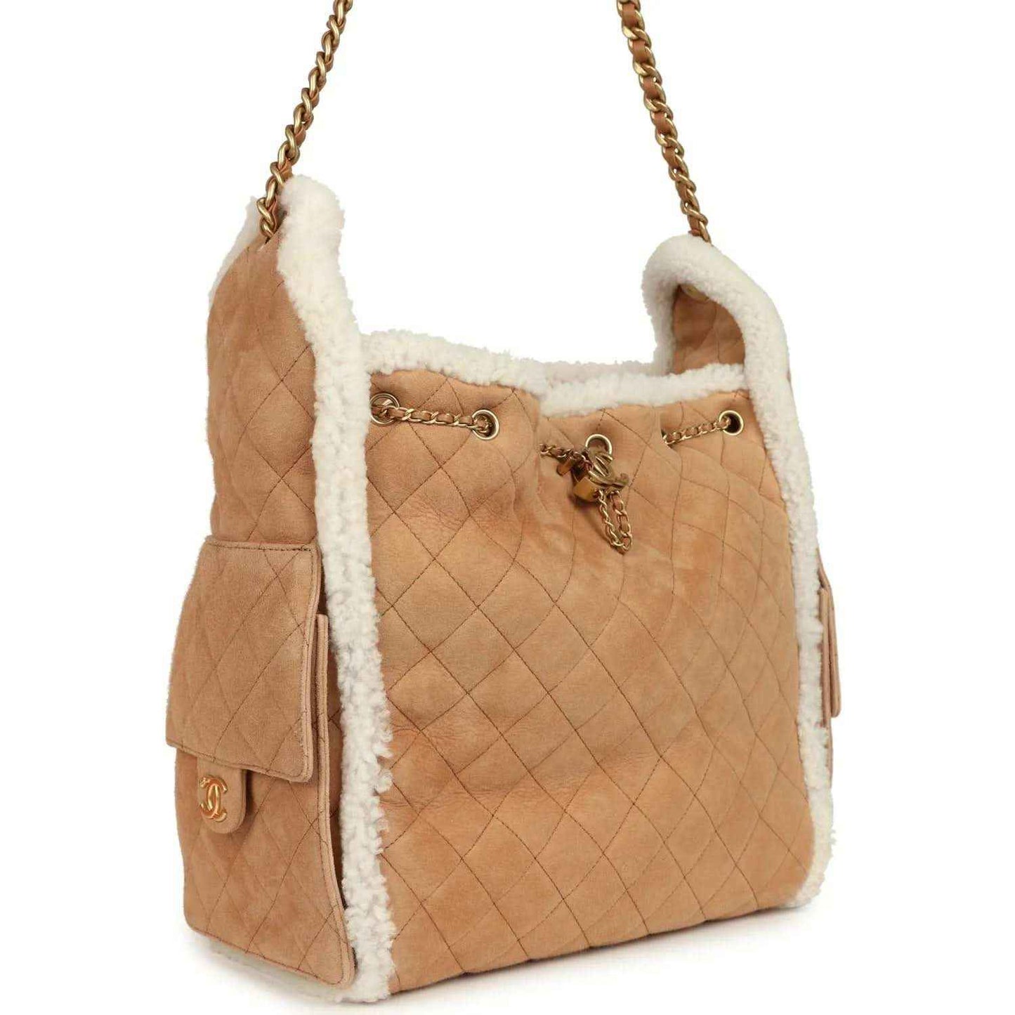Beige quilted hobo bag with white shearling trim, gold chain strap and side tassel details