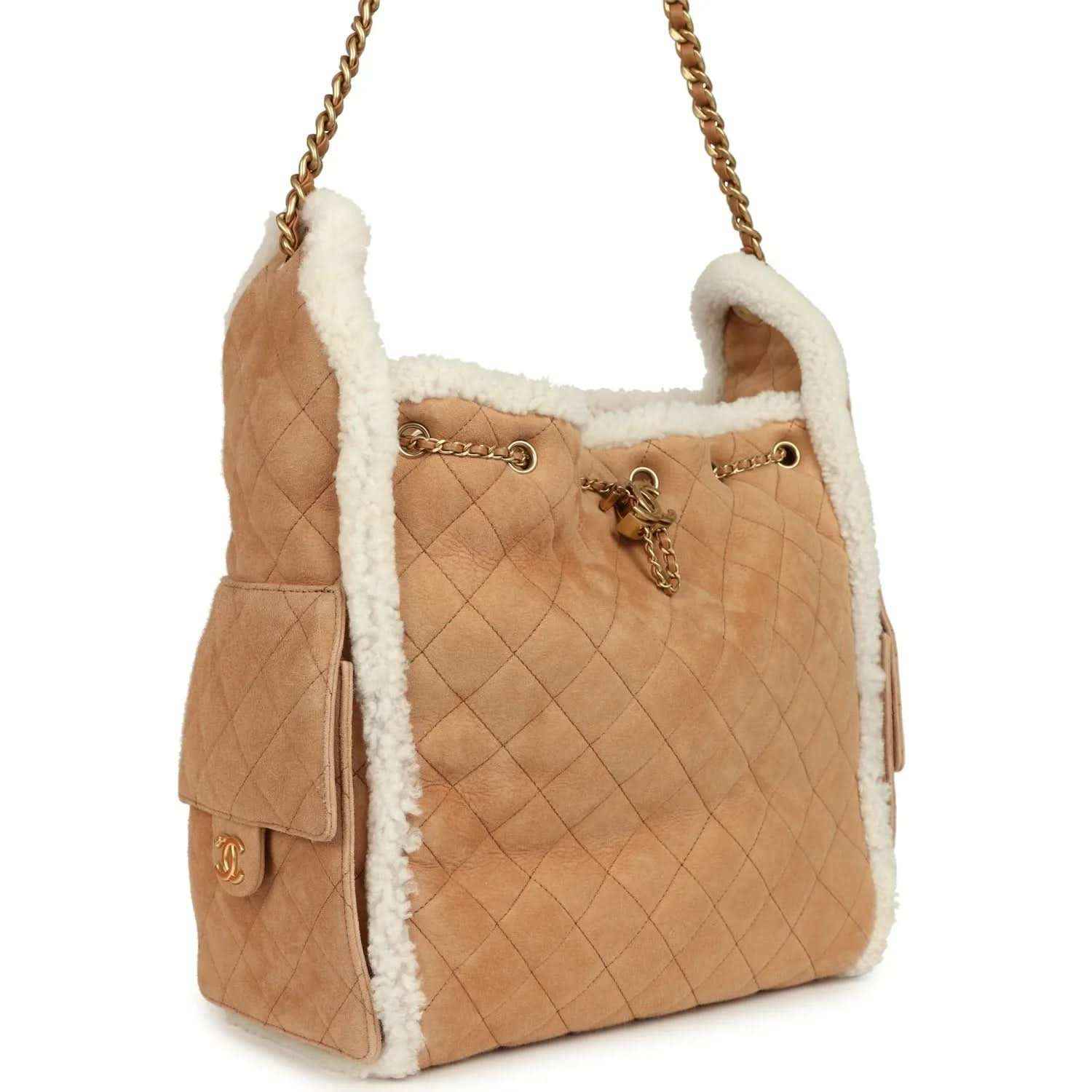 Beige quilted hobo bag with white shearling trim, gold chain strap and side tassel details