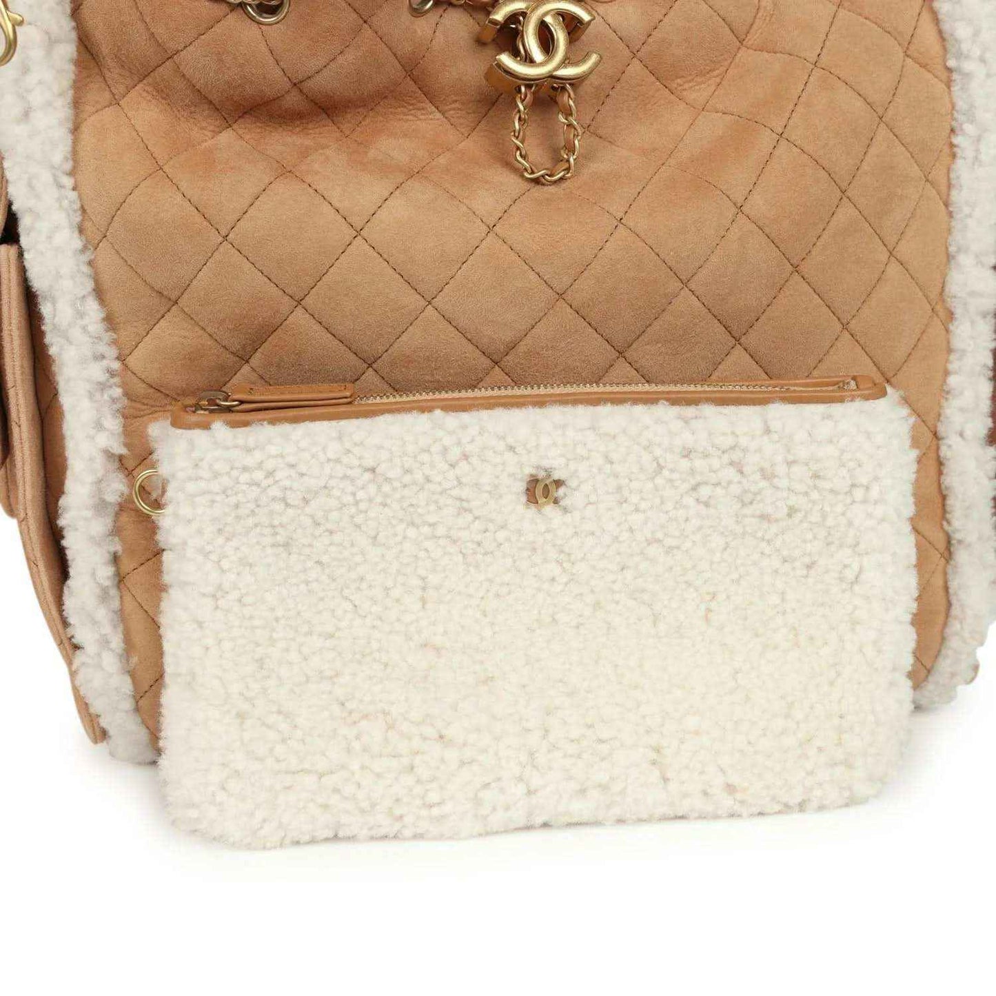 Beige hobo bag interior with white shearling zip pouch and small gold logo charm