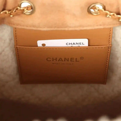 Chanel hobo bag interior label with gold logo text and white tag on beige leather lining