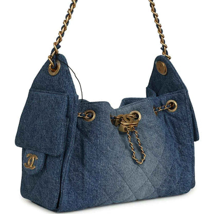 Blue washed denim mini hobo bag with chain strap, cinched top, and gold hardware details