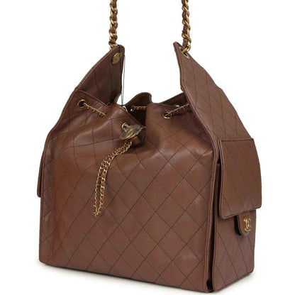 Brown quilted hobo bag with chain strap, side pocket tabs, and Chanel clasp