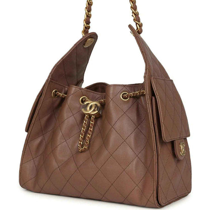 Brown quilted handbag with gold chain, CC charm, and tassel detail