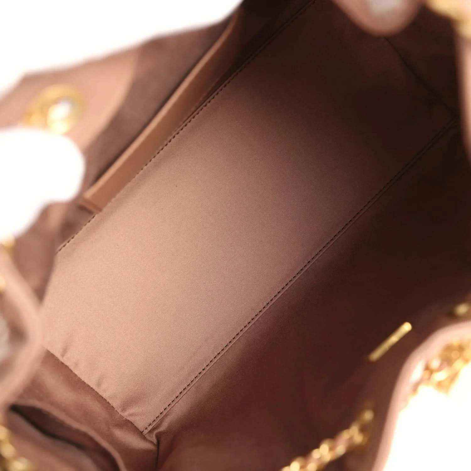Brown leather bag interior with fabric lining and stitched edge