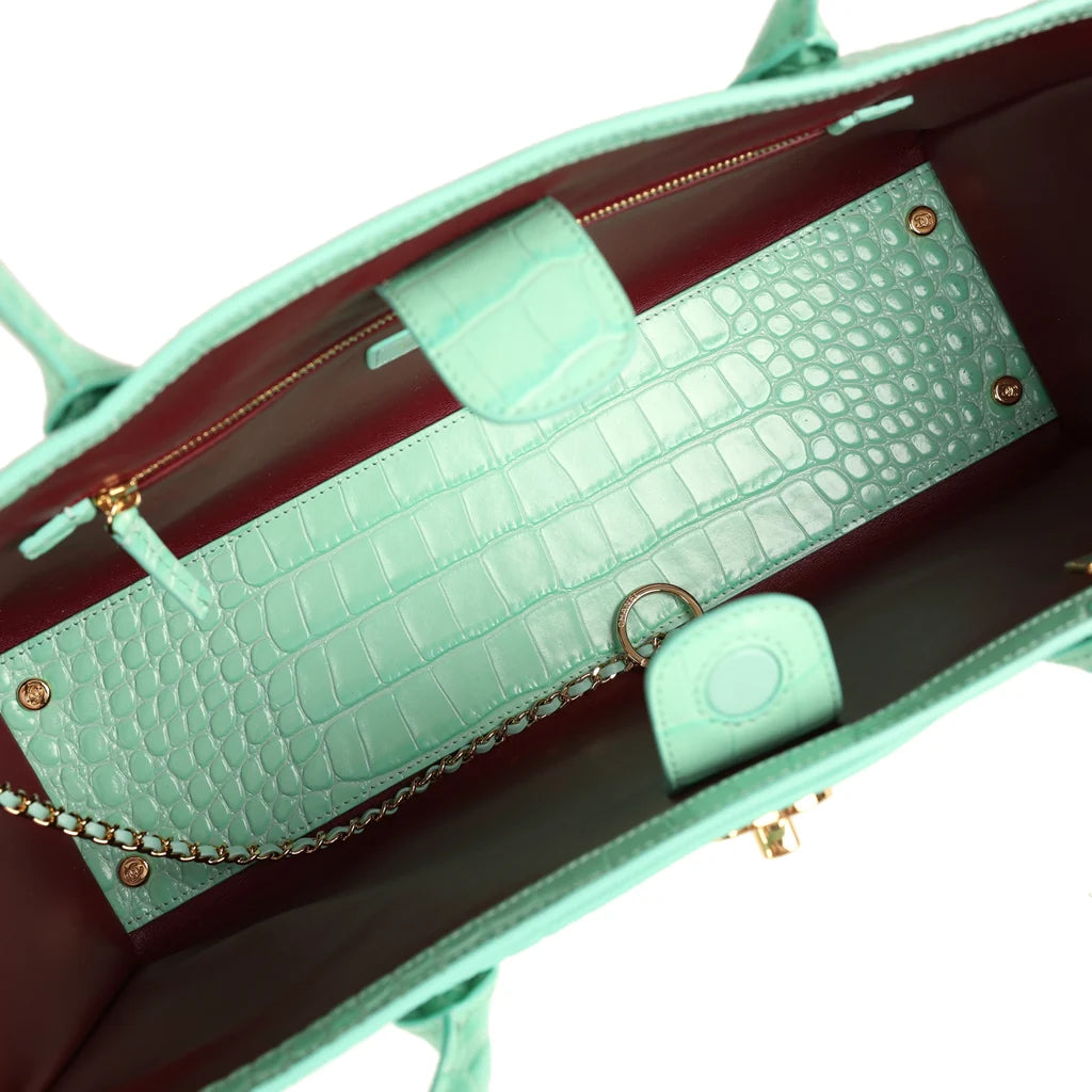 Teal croc-embossed leather interior with chain strap, pocket, and burgundy lining
