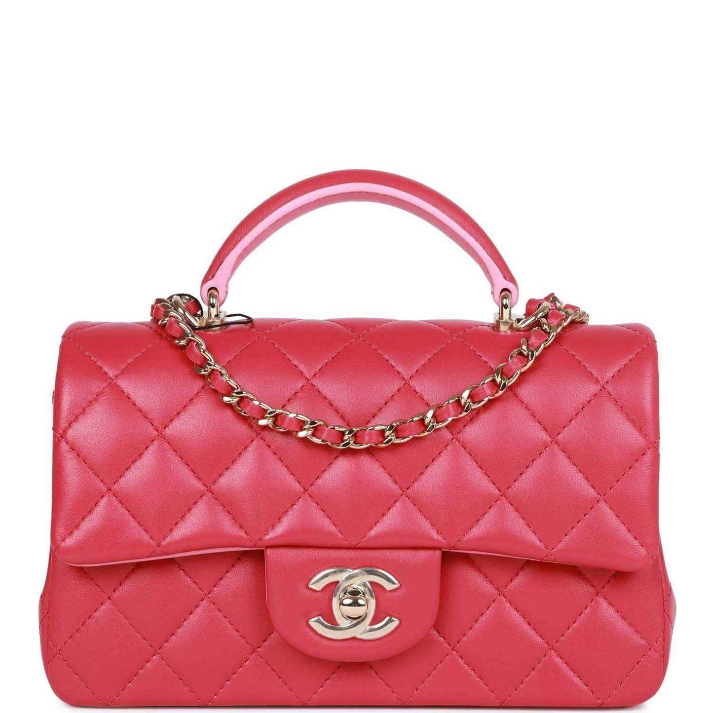 Pink quilted mini flap bag with top handle, chain strap, Chanel turn-lock clasp.