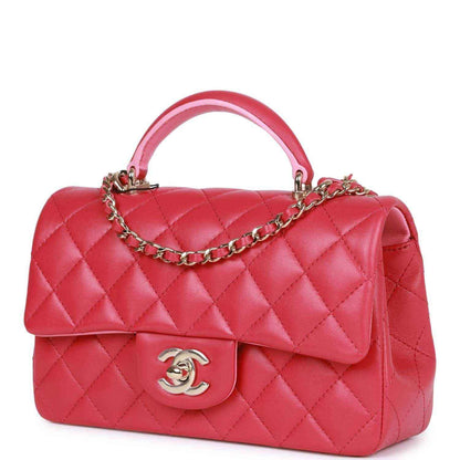 Pink quilted mini flap bag with top handle and chain strap, front Chanel logo.