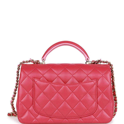 Pink quilted mini flap bag with front logo, top handle, and chain strap.