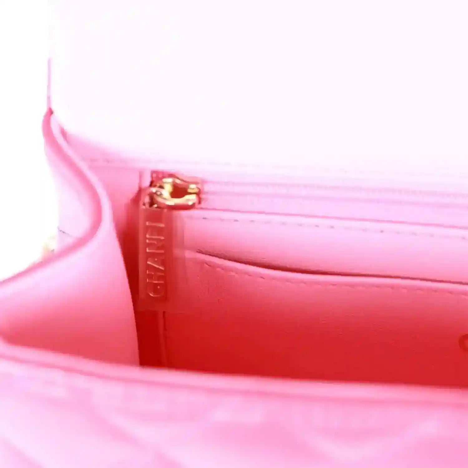 Pink fabric lining with gold-tone zipper pull and pull tab.