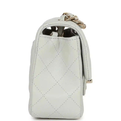 Light grey quilted mini flap bag side view with chain and interior opening